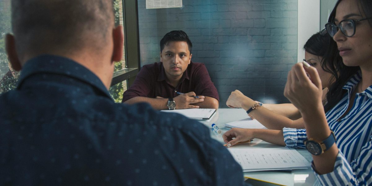 Business professionals in a meeting, calmly discussing potential future risks and developing contingency plans.
