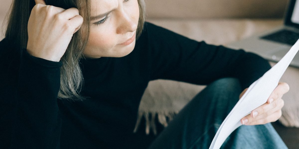 A person thoughtfully reviewing market data and reports, symbolizing the search for reliable information.