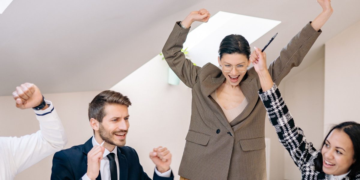 A professional team celebrating a successful project completion, illustrating the rewarding career growth and earning potential in Dubai's real estate marketing.
