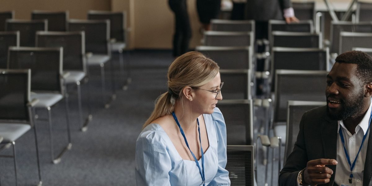 Professionals engaging in conversation at a business event, highlighting the crucial role of networking for career advancement and job opportunities.