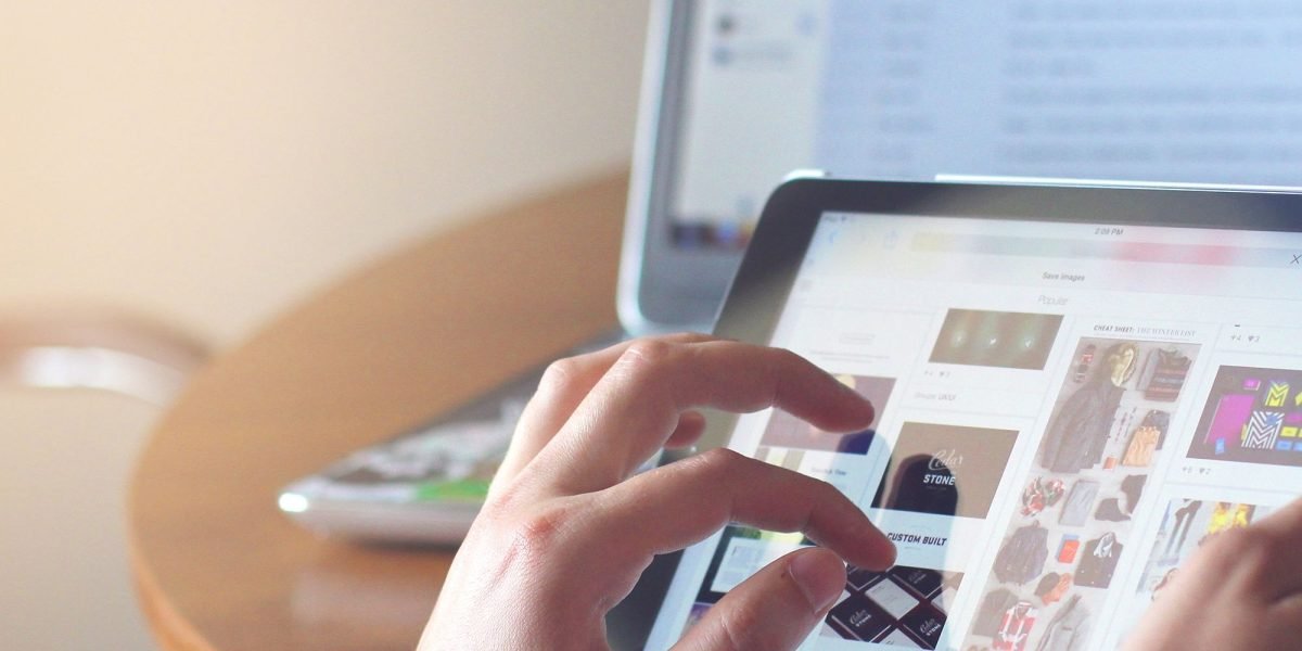 A person engages with real estate listings on a digital tablet, reflecting the modern online property search experience.