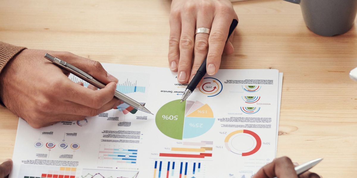 A group of professionals collaborating and discussing market data, emphasizing a data-driven approach to real estate strategy.