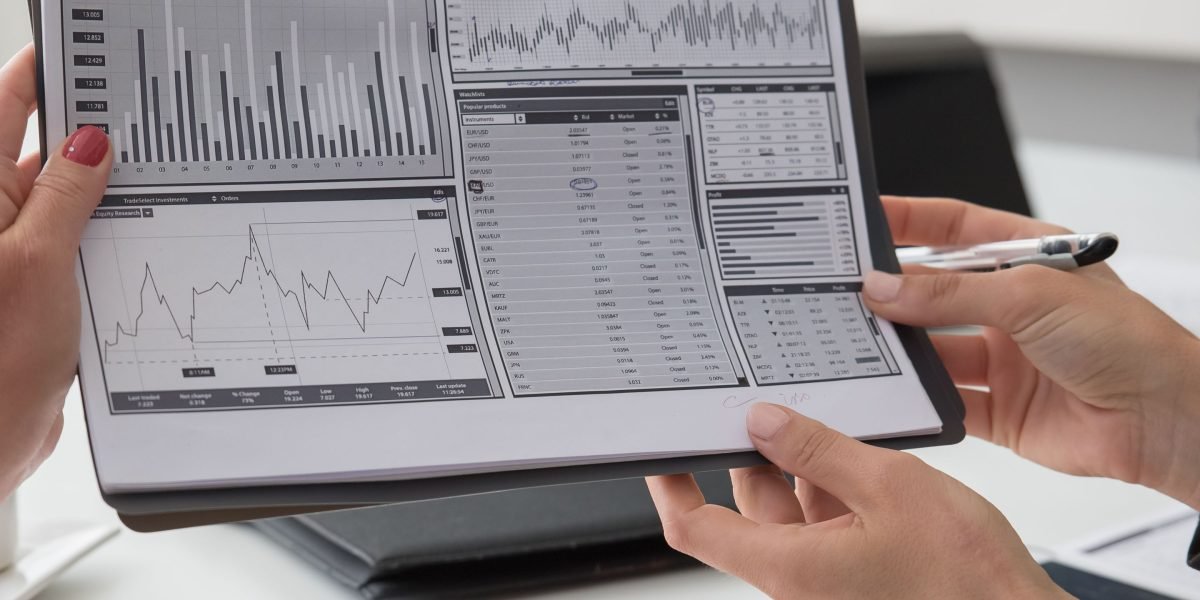 A business professional meticulously reviewing various reports and charts, symbolizing the process of measuring ROI and performance.