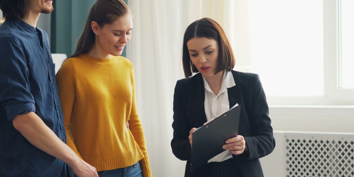 A young family thoughtfully discussing their options for purchasing a new home, reflecting common demand drivers.