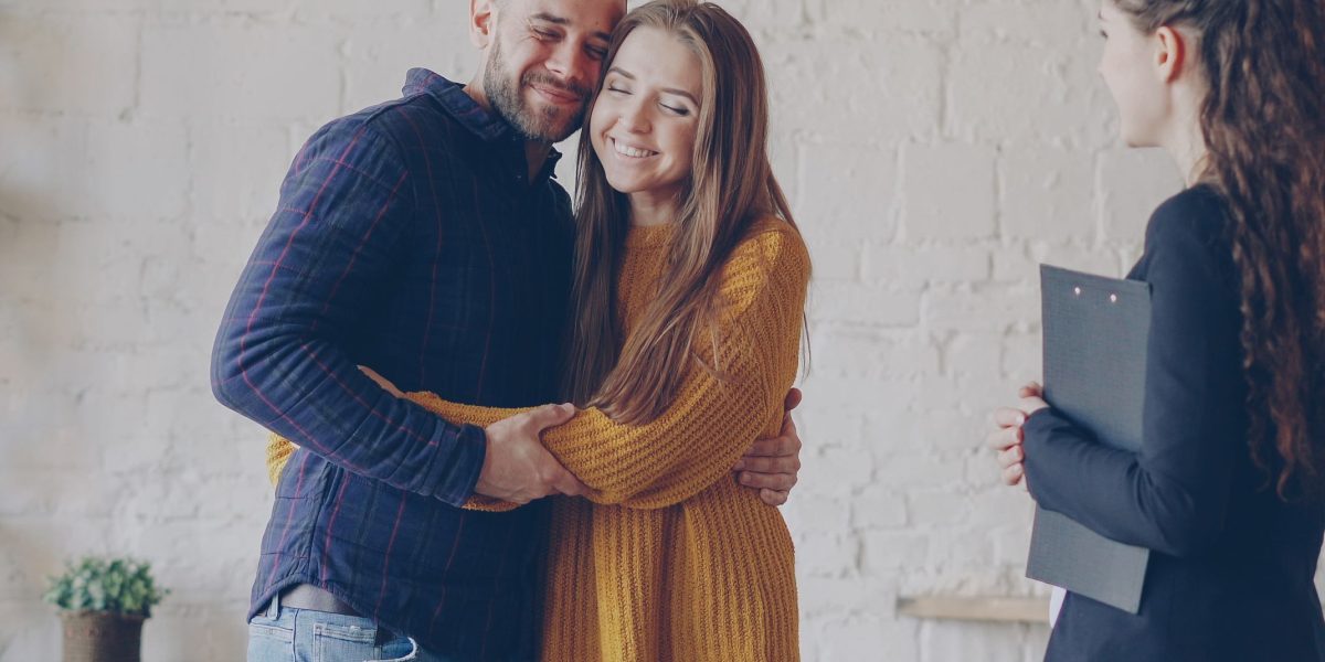 A professional couple celebrating a successful property purchase, symbolizing the culmination of the buying process.