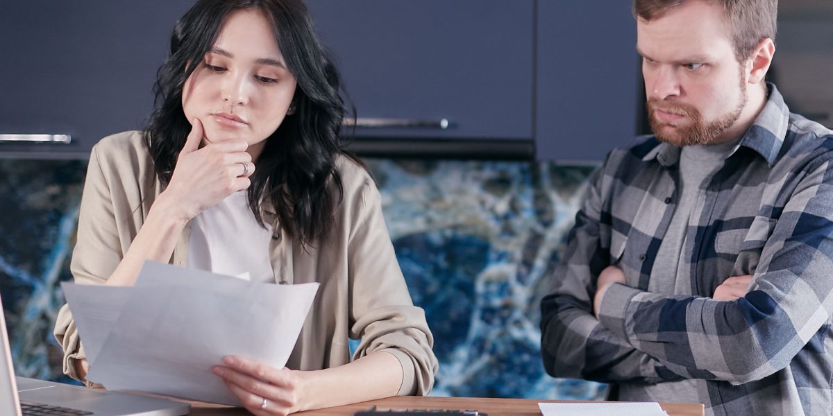 A couple carefully reviews financial documents, planning their long-term property investment.