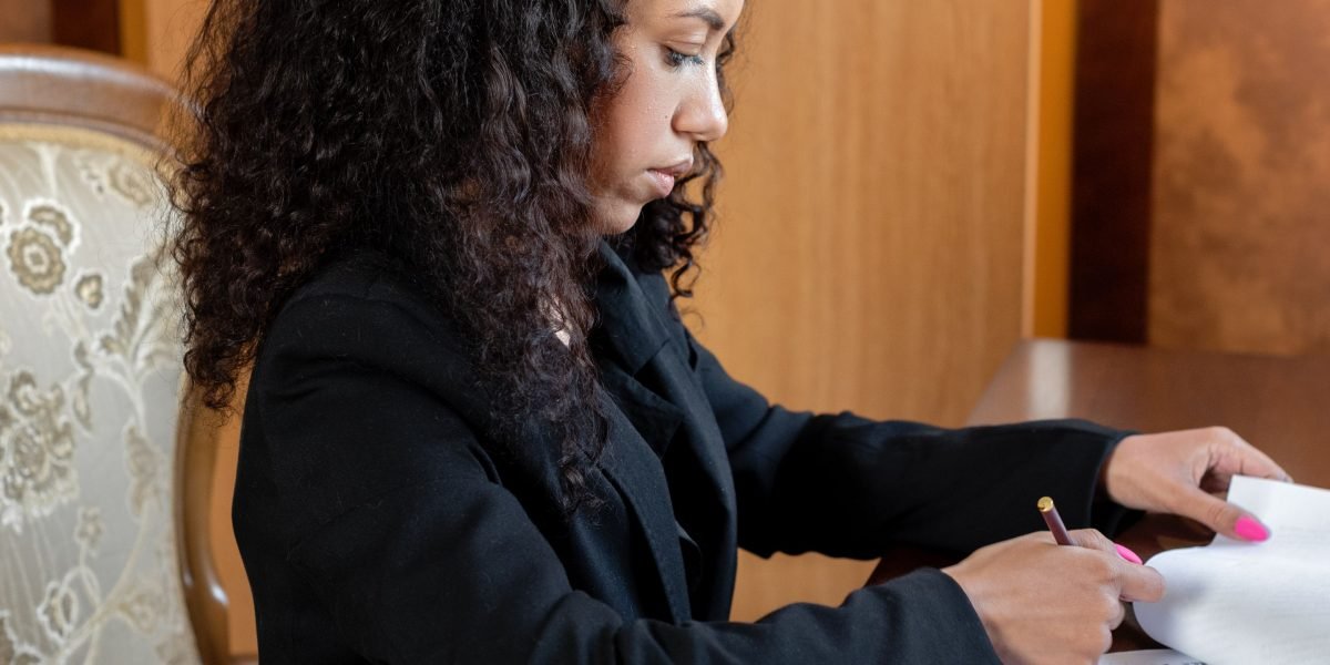 A person meticulously reviewing legal documents or contracts, representing the administrative aspects of relocation and employment in Dubai.